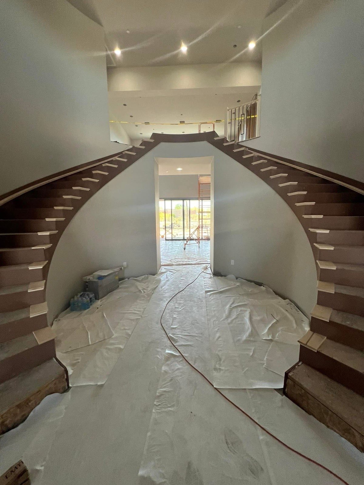 Dramatic dual staircase in a ground-up luxury custom home, under construction